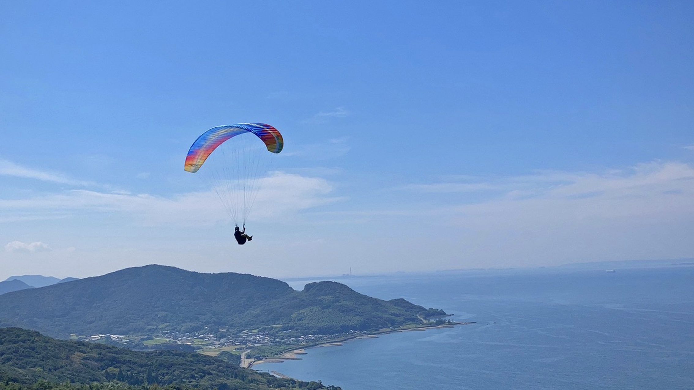 パラグライダーと海と山